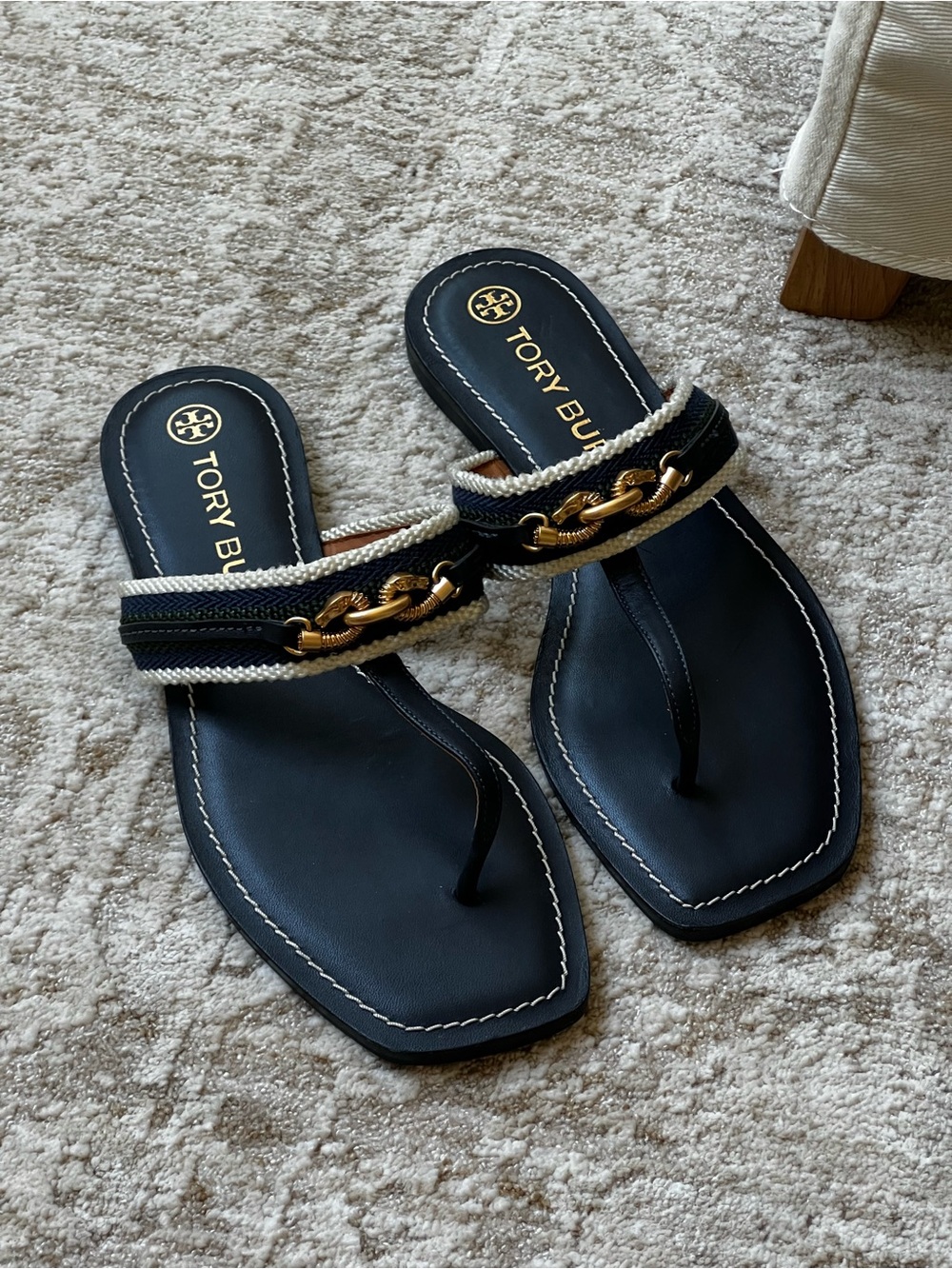 Tory Burch navy slides with gold details.